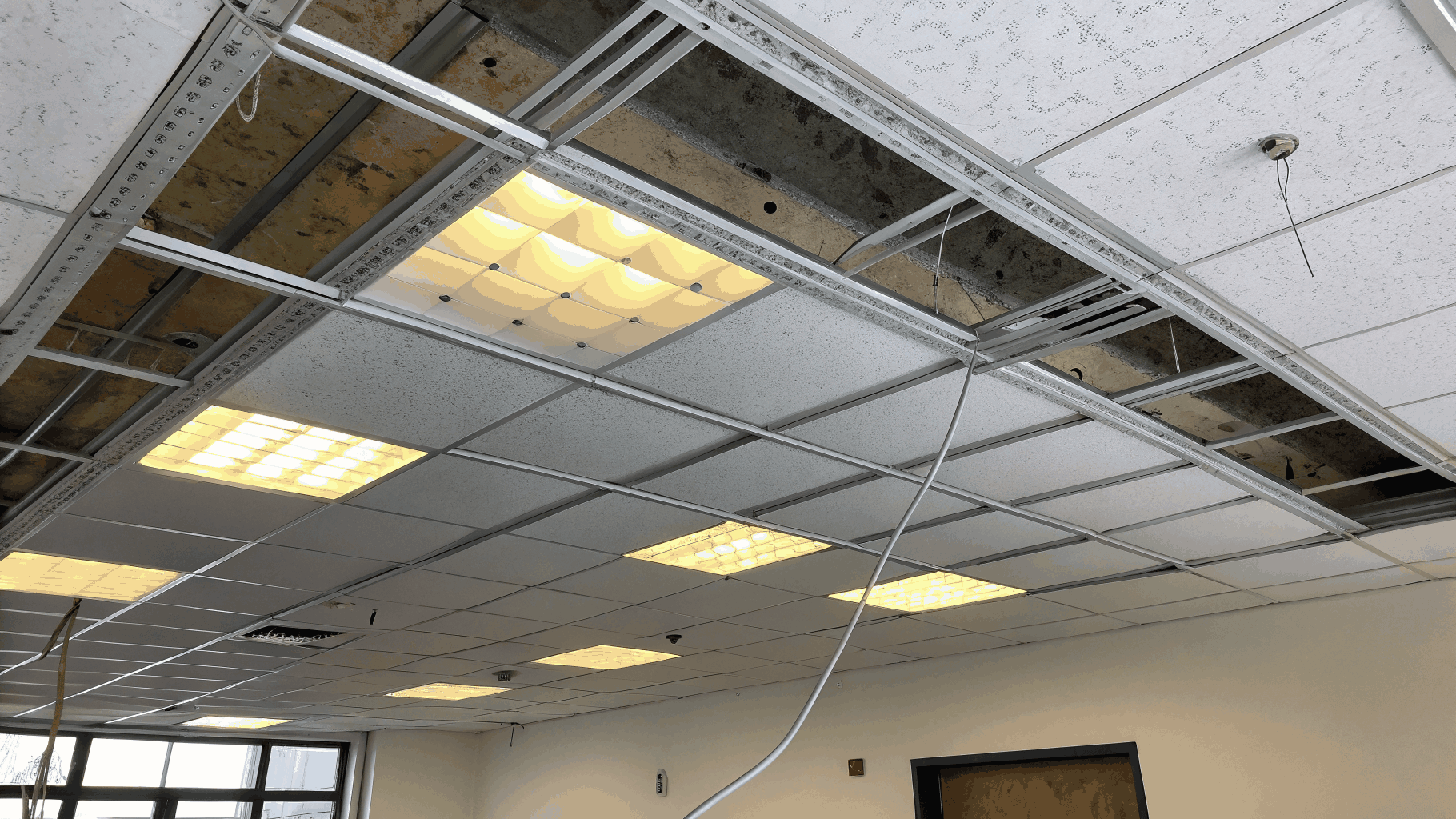 Suspended T-bar acoustical ceiling grid installation in a commercial space